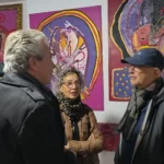 20250119Asistenes a la exposición con cuadros detrás